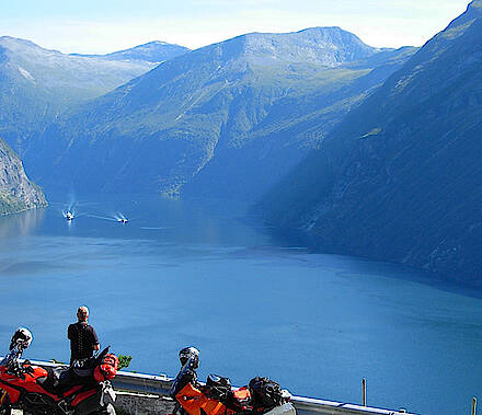 Motorradfahrer blickt auf den Geirangerfjord in Norwegen