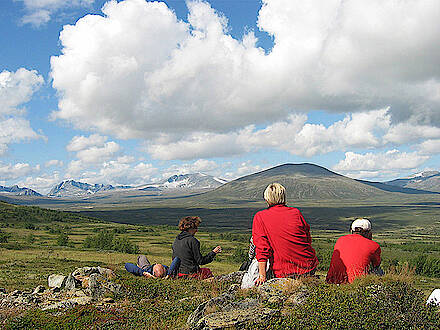 Wanderer sitzen im Dovrefjell in Norwegen und schauen auf Gebirgskette