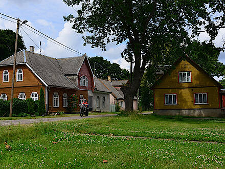 BMW F800 GS in einem Dorf im Baltikum zwischen zwei alten Häusern