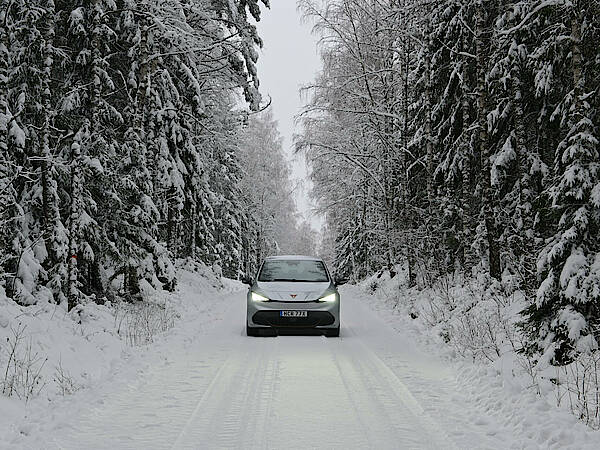 Ein E-Auto im Winter in Schweden auf einer verschneiten Straße