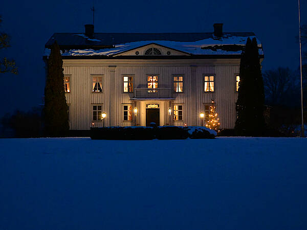 Ein Herrenhaus in Småland im Winter in der Dämmerung