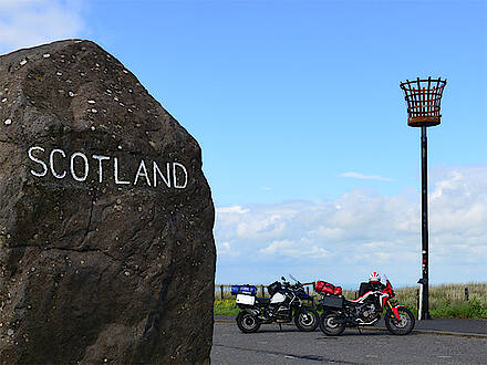 Schottland Grenzstein mit Feuerkorb und zwei Motorrädern
