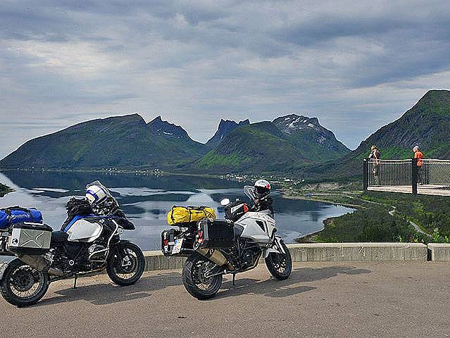 Motorräder vor einer Aussichtsplattform auf der Insel Senja mit Blick über das Meer und die Berge