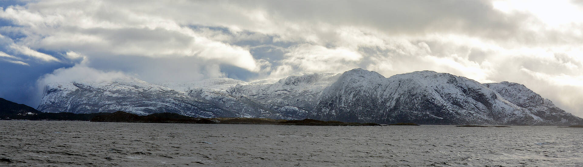 Schneebedeckte Berge am Meer