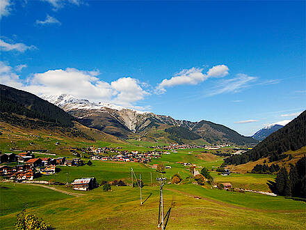 Grünes Tal vor schneebedeckten Gipfeln in der Schweiz