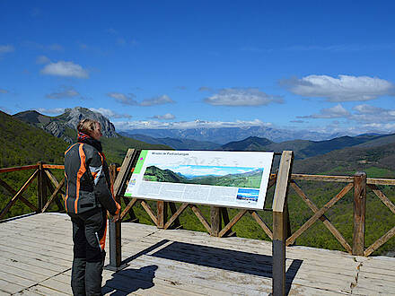Motorradfahrerin blickt am Aussichtspunkt Mirador auf die Picos de Europa