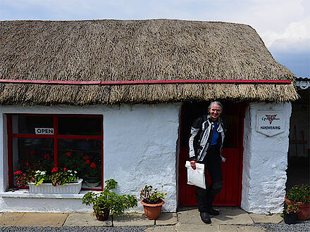 Motorradfahrerin vor Cindy Grahams Handweaving Studio, Donegal, Irland