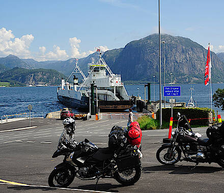 Motorräder und Fähre an einem Fjord in Norwegen
