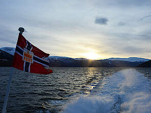 Eine norwegische Postflagge weht im Morgenlicht