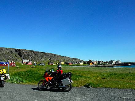 Motorräder vor bunten Holzhäusern an der Barentssee in Norwegen