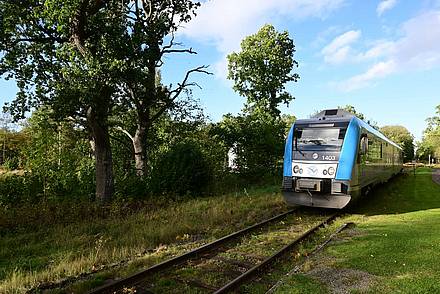 Ein Zug auf der Kinnekullebahn erreicht einen Bahnhof