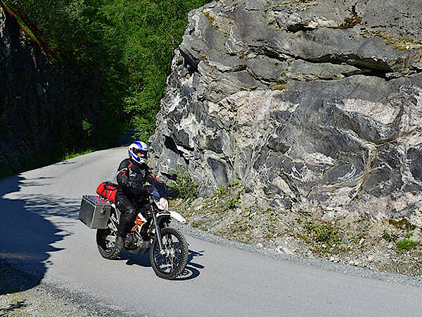 KTM Enduro auf kleiner Landstraße im Fell in Norwegen