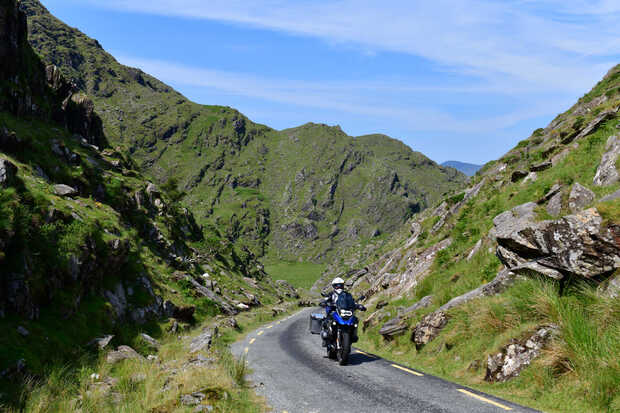 Ein Motorrad fährt auf einer Landstraße in Irland