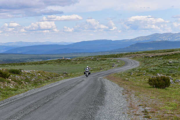 Ein Motorrad fährt auf einer Gravelstraße in Norwegen